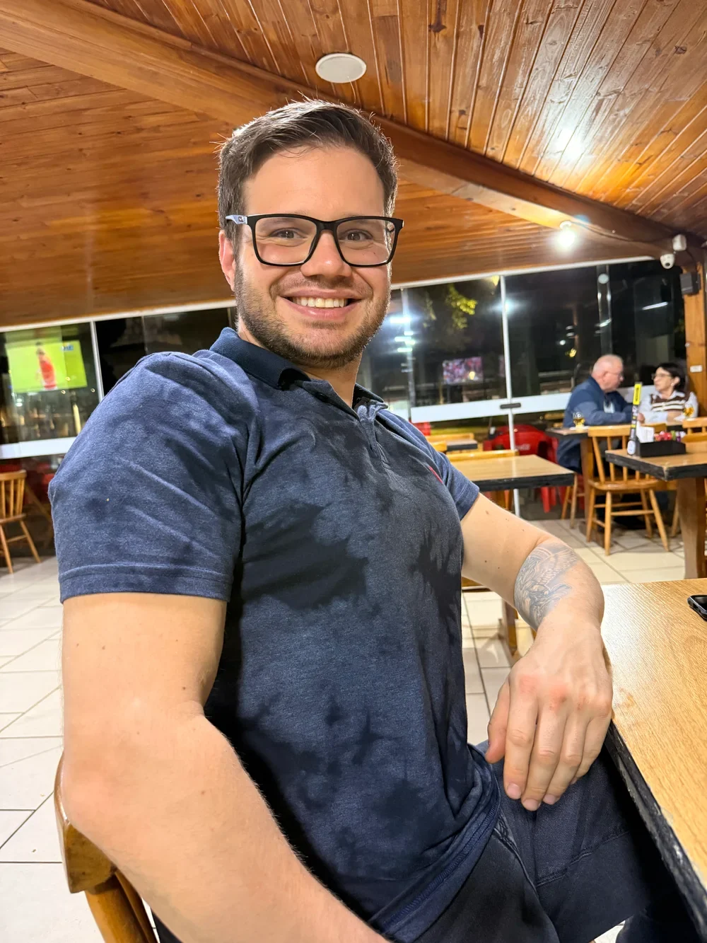 Miguel Piccin sorrindo, sentado à mesa
